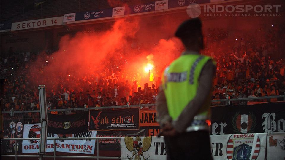 Polisi yang berjaga sepanjang pertandingan tetap tenang meskipun penonton mulai menyalakan flare.